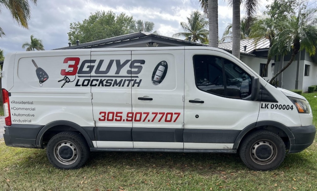 A white locksmith van with text and contact details, parked on grass under cloudy skies, surrounded by palm trees.